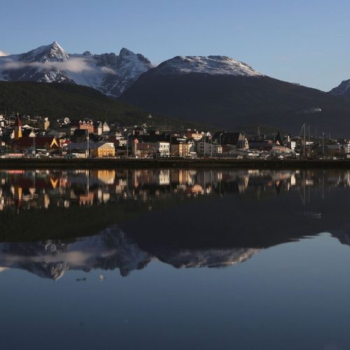 USHUAIA, ARGENTINA - NOVEMBER 05:  Ushuaia is reflected near the main docks on November 5, 2017 in Ushuaia, Argentina. Ushuaia is situated along the southern edge of Tierra del Fuego, in the Patagonia region, and is commonly known as the 'southernmost city in the world'. The city's main fresh water supply comes from the retreating Martial Glacier, which may be at risk of disappearing. In a 2015 report, warming temperatures led to the loss of 20 percent of the mass and surface of glaciers in Argentina over the previous 50 years, according to Argentina's Institute of Nivology, Glaciology and Environmental Sciences (IANIGLIA). Ushuaia and surrounding Tierra del Fuego face other environmental challenges including a population boom leading to housing challenges following an incentivized program attracting workers from around Argentina. Population in the region increased 11-fold between 1970 and 2015 to around 150,000. An influx of cruise ship tourists and crew, many on their way to Antarctica, has also led to increased waste and pollution in the area sometimes referred to as 'the end of the world'.  (Photo by Mario Tama/Getty Images)