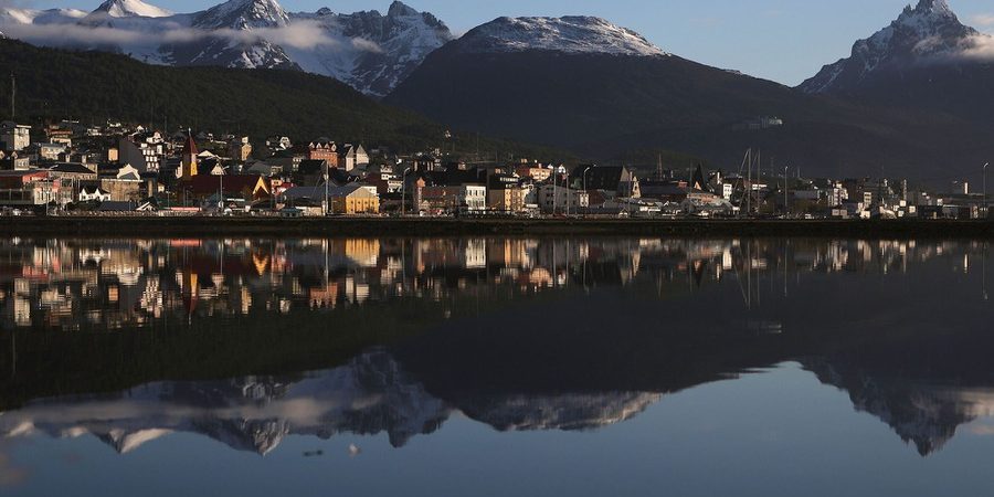 USHUAIA, ARGENTINA - NOVEMBER 05:  Ushuaia is reflected near the main docks on November 5, 2017 in Ushuaia, Argentina. Ushuaia is situated along the southern edge of Tierra del Fuego, in the Patagonia region, and is commonly known as the 'southernmost city in the world'. The city's main fresh water supply comes from the retreating Martial Glacier, which may be at risk of disappearing. In a 2015 report, warming temperatures led to the loss of 20 percent of the mass and surface of glaciers in Argentina over the previous 50 years, according to Argentina's Institute of Nivology, Glaciology and Environmental Sciences (IANIGLIA). Ushuaia and surrounding Tierra del Fuego face other environmental challenges including a population boom leading to housing challenges following an incentivized program attracting workers from around Argentina. Population in the region increased 11-fold between 1970 and 2015 to around 150,000. An influx of cruise ship tourists and crew, many on their way to Antarctica, has also led to increased waste and pollution in the area sometimes referred to as 'the end of the world'.  (Photo by Mario Tama/Getty Images)