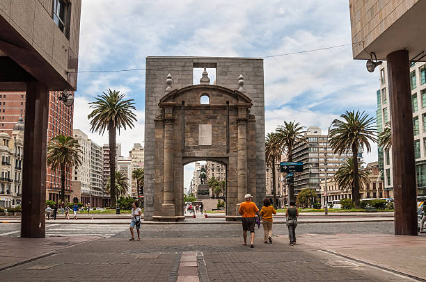 Montevideo, Uruguay - December 15, 2012: People walking on Sarandi pedestrian street, in the Ciudad Vieja area with the landmark Puerta de la Ciudadela (Citadel Gate) in the center.